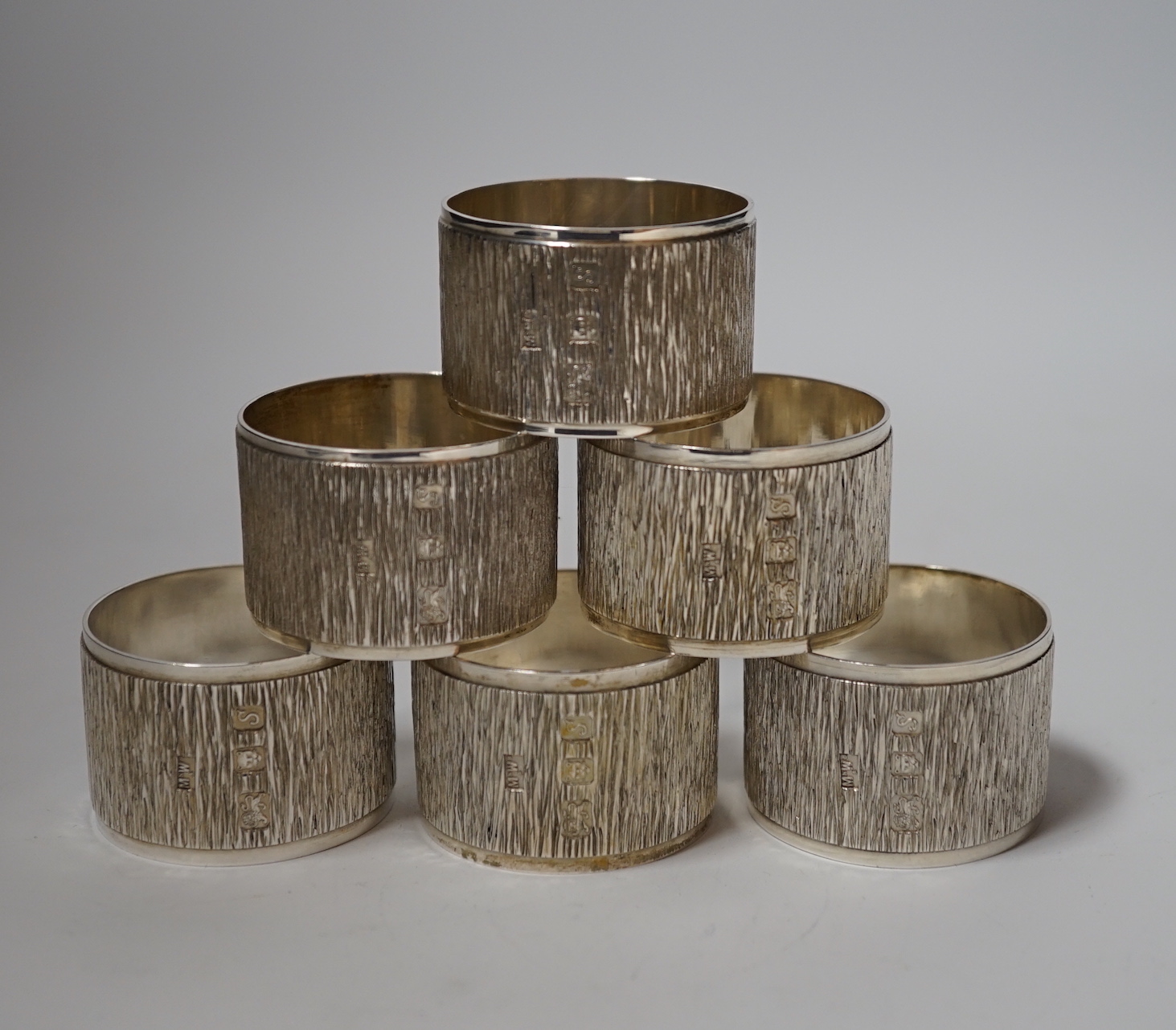 A set of six Elizabeth II textured silver napkin rings, Mappin & Webb, London, 1973, 46mm, 10.9oz, with Mappin & Webb box.